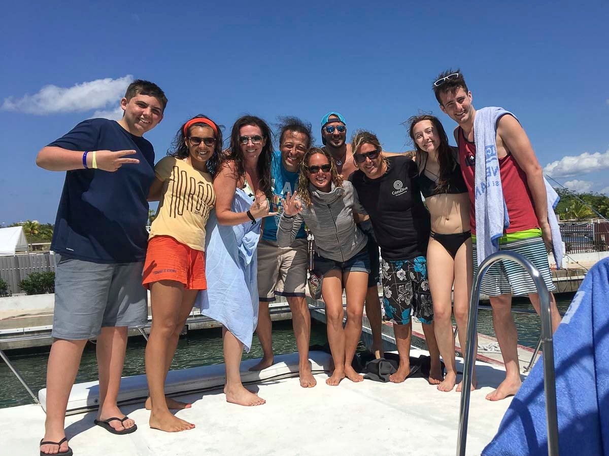 Group of smiling scuba divers on the quay before the trip, in Cozumel.